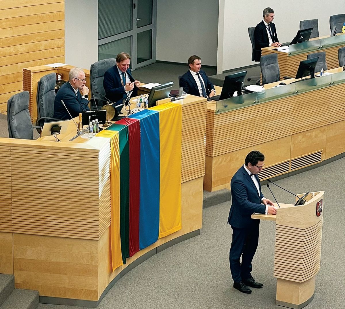 Депутати виступають на тлі литовського і українського прапорів.