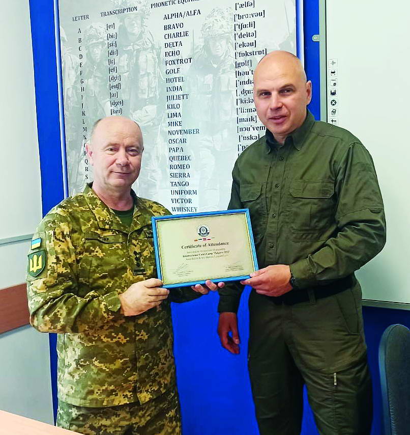 Юрій Гусар і Річардас Жилайтіс тримають сертифікат про перебування групи ліцеїстів-«крутян» у Литві на польовому вишколі «Жальгіріс».