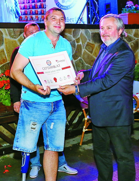 Іван Гаврон вручає Андрієві Забігайлу сертифікат на річний запас пива.