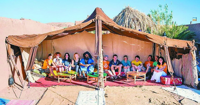  Група туристів кайфує від відвідин бедуїнського шатра. Їжі на столах — обмаль, зате є приємна компанія. 