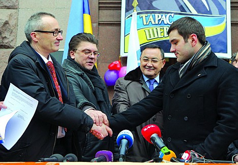 Після підписання документів про звільнення будівлі КМДА активіст Майдану Руслан Андрійко (справа) і посол Швейцарії в Україні Крістіан Шоненберг (зліва) потиснули один одному руки.