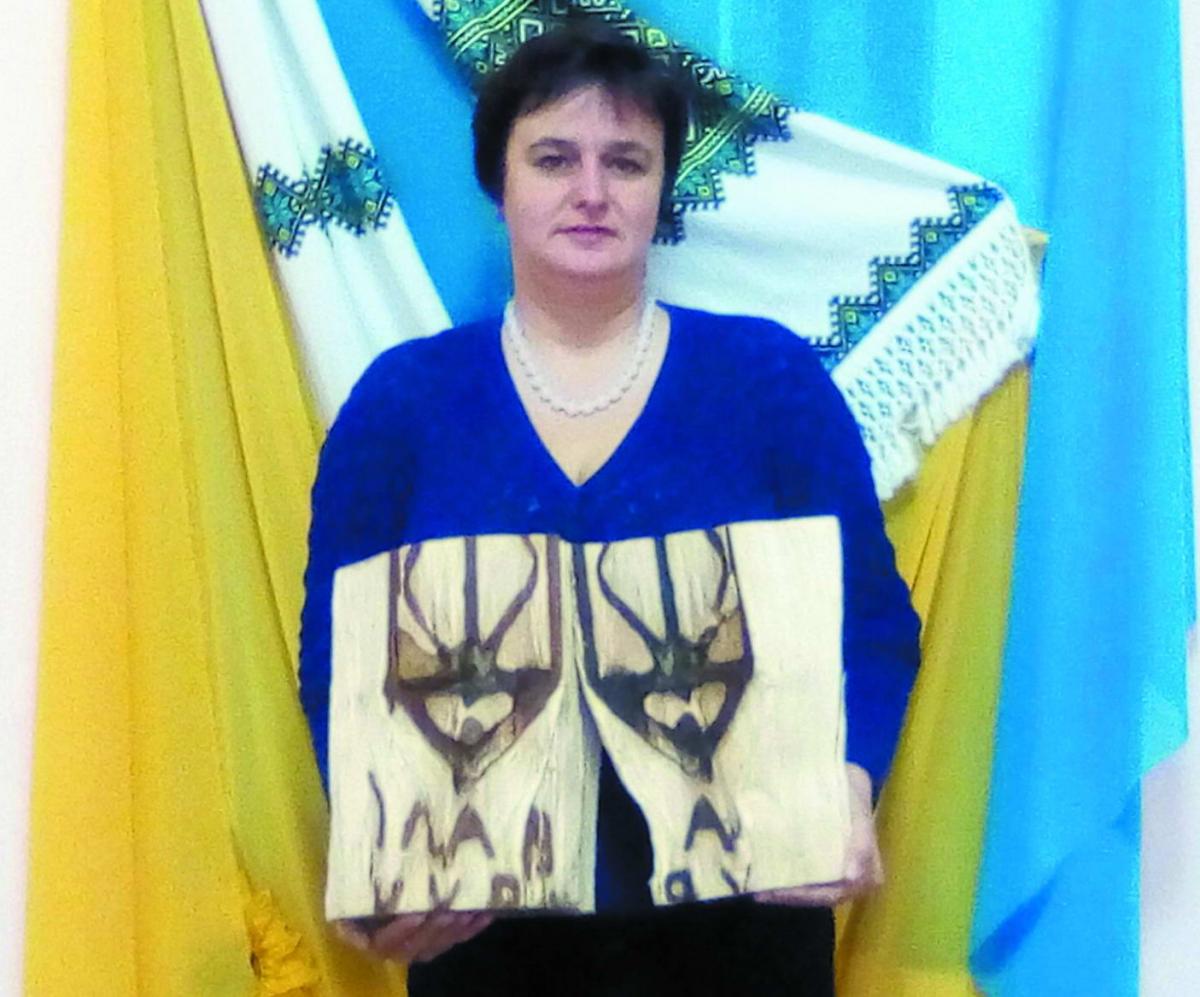 Голова територіальної громади Галина Огородник з “патріотичним” поліном, яке поповнить сільський музей.