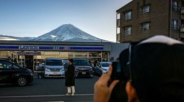 Фудзіяму можна зняти з багатьох локацій містечка Фудзі-Каваґутіко. Але одна точка особливо популярна: вулкан височіє на тлі крамниці поширеної в Японії мережі Lawson. Фото AFP