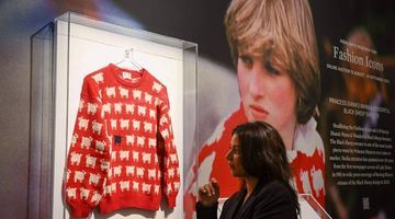 На фото: Червоний светр, на якому зображені одна чорна вівця й багато білих, принцеса Діана вперше одягнула 1981 року, коли стала офіційною нареченою принца Чарльза. Фото AFP.